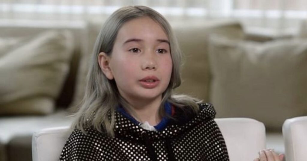 A photo of Lil Tay speaking with a black hoodie on as she is said to be dead