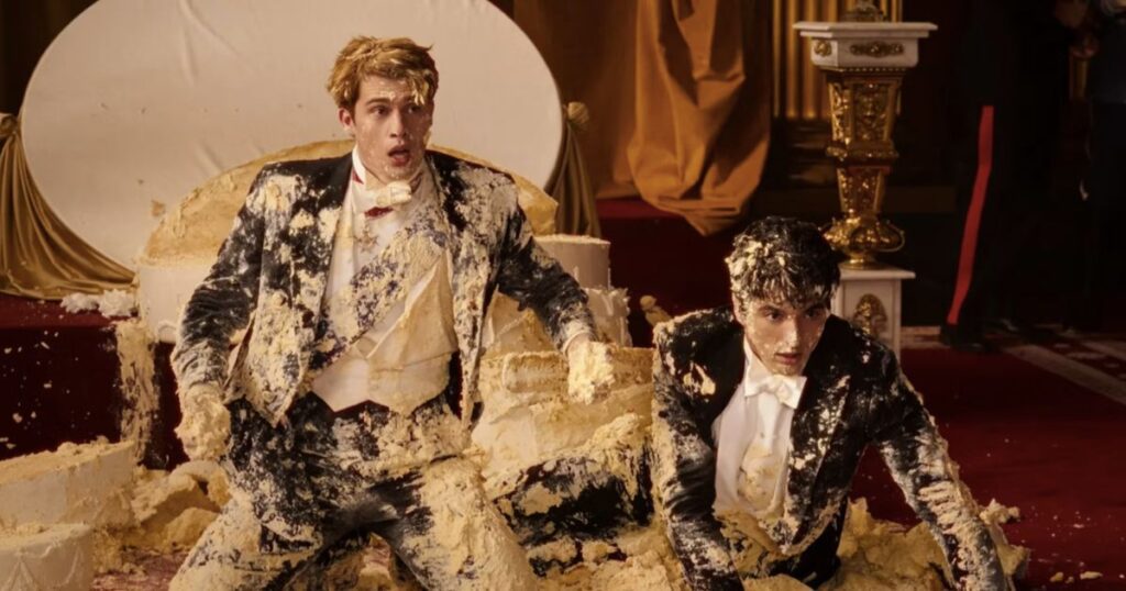 nicholas galtizine and taylor perez covered in cake wearing suits in article about red white & royal blue book differences