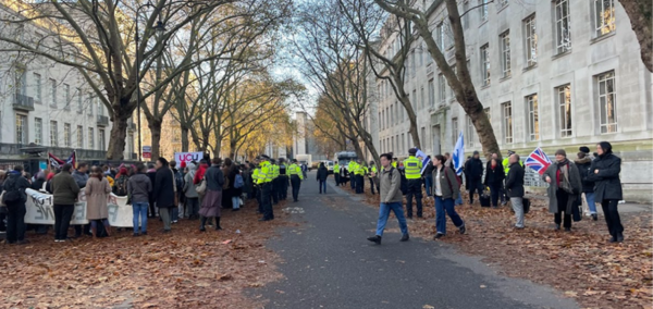 A group of Pro-Palestine protestors demonstrate outside of LSE, with Police at their back. Across the street, a smaller group of Pro-Israel protestors, with Police in front of them.