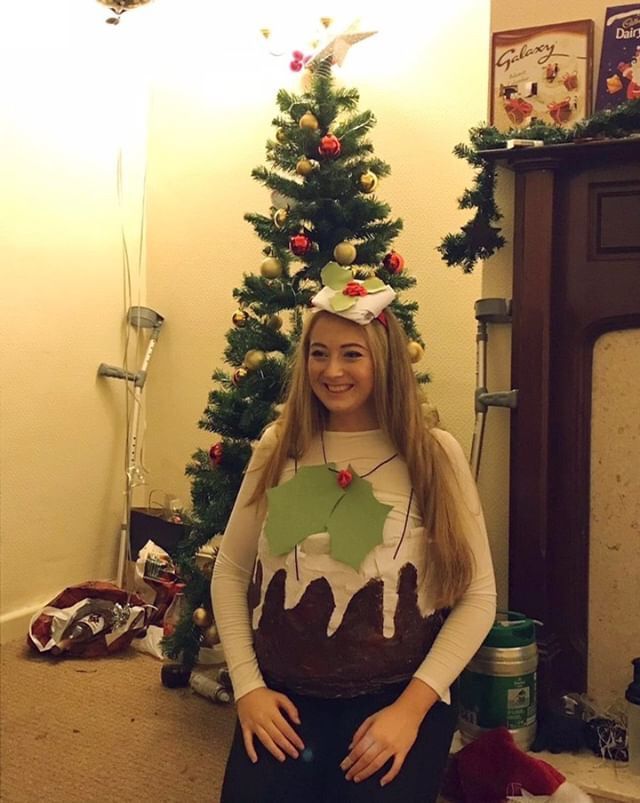 Image may contain: Indoors, Photography, Portrait, Photo, Christmas Tree, Pants, Pottery, Potted Plant, Vase, Jar, Female, Ornament, Furniture, Chair, Face, Costume, Human, Person, Plant, Tree, Apparel, Clothing
