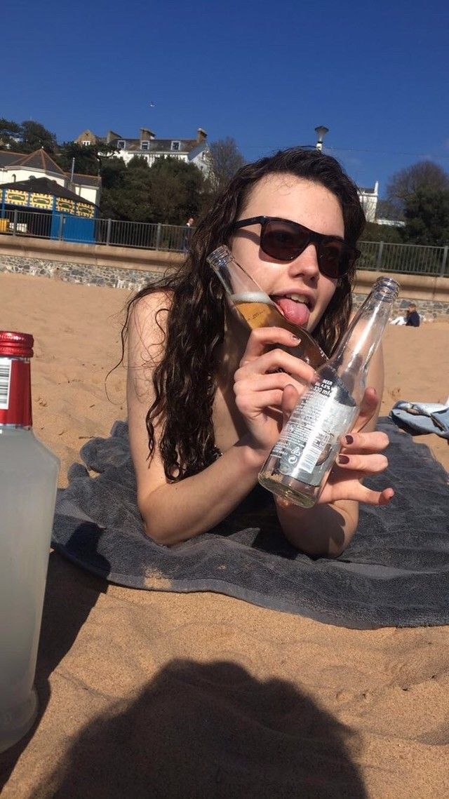 Image may contain: Liquor, Shoreline, Beach, Water, Ocean, Coast, Sea, Female, Face, Nature, Sand, Outdoors, Vacation, Drinking, Beer, Bottle, Alcohol, Beverage, Drink, Human, Person, Accessory, Sunglasses, Accessories