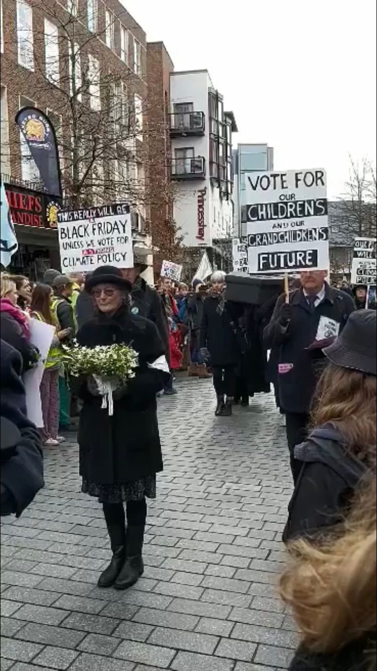 Image may contain: Blossom, Flower, People, Text, Pedestrian, Plant, Protest, Parade, Crowd, Human, Person