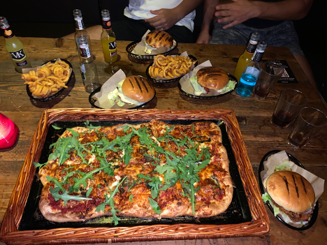 A selection of food at Timepiece. Includes burgers and a pizza