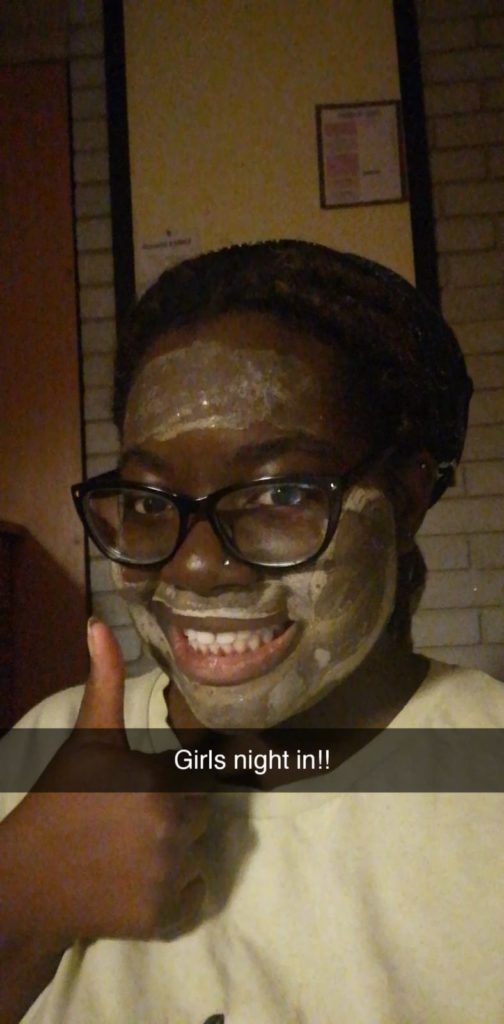 Wearing a mud mask, putting thumbs up and captionned 'Girls Night In'