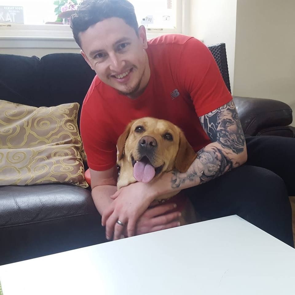 Image may contain: Smile, Skin, Female, Man, Pillow, Dog, Pet, Puppy, Canine, Mammal, Animal, Face, Indoors, Room, Living Room, Cushion, Person, Human, Couch, Furniture