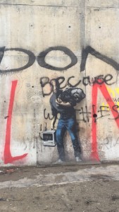 Banksy's mural of Steve Jobs, the son of a Syrian Immigrant appears on a wall at the edge of the 'Jungle'
