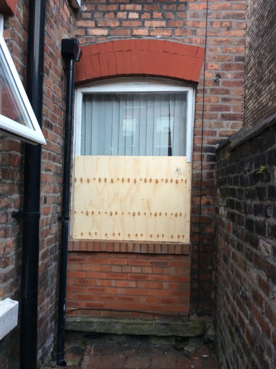 The window remains broken but boarded up