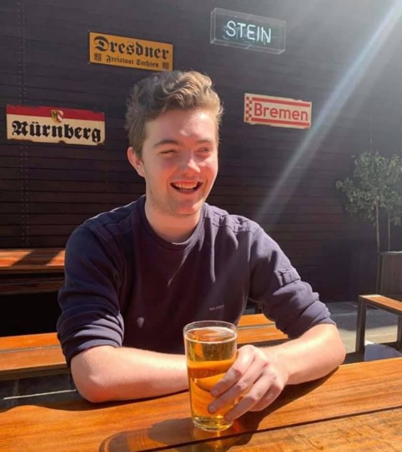 Image may contain: Portrait, Photo, Photography, Chair, Furniture, Wood, Lager, Face, Beer Glass, Glass, Drink, Beverage, Beer, Alcohol, Human, Person