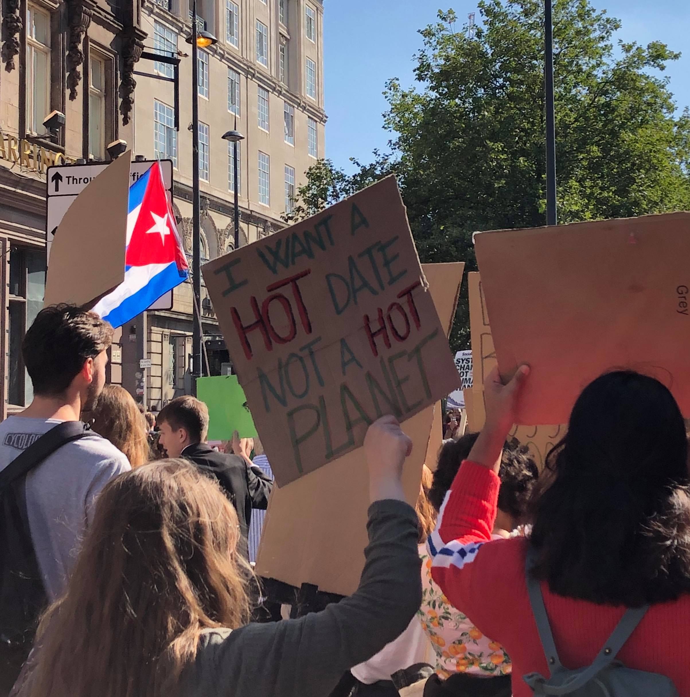 Image may contain: Banner, Flag, Symbol, Crowd, Text, Human, Person
