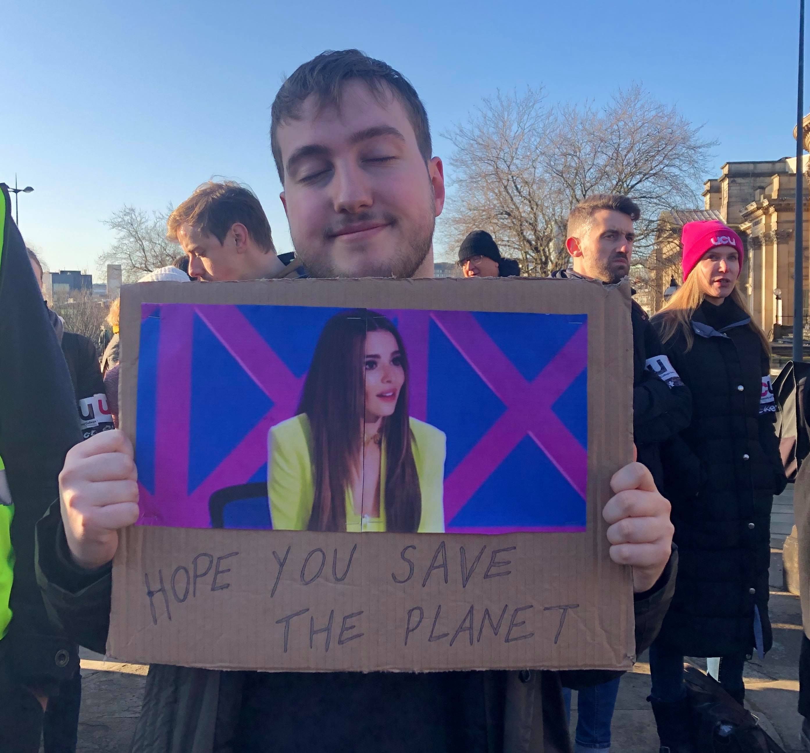 Image may contain: Crowd, Clothing, Apparel, Label, Human, Person, Text, Banner