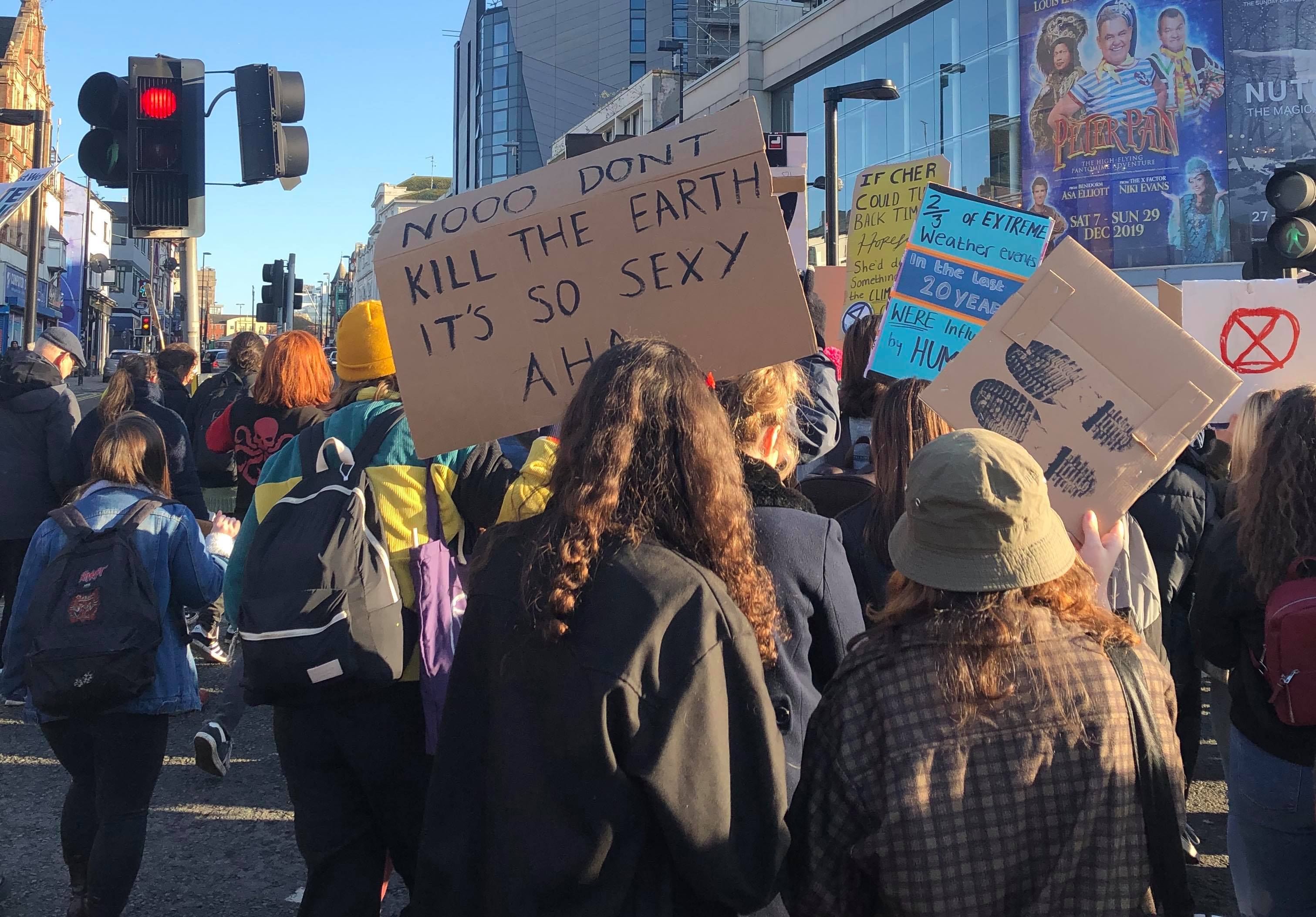 Image may contain: Parade, Apparel, Clothing, Light, Traffic Light, Text, Pedestrian, Crowd, Human, Person