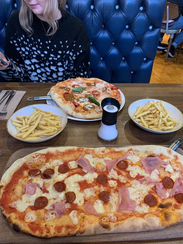 Image may contain: Furniture, Chair, Meal, Human, Person, Food, Pizza