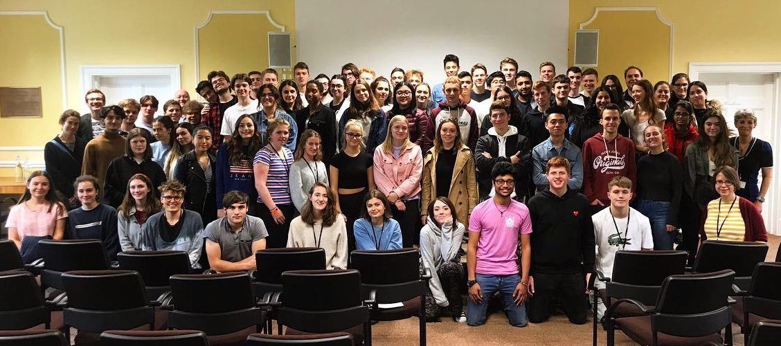 Image may contain: Sitting, Smile, People, Face, Female, Audience, Crowd, Jeans, Denim, Room, Indoors, Classroom, Chair, Furniture, Student, School, Apparel, Pants, Clothing, Person, Human