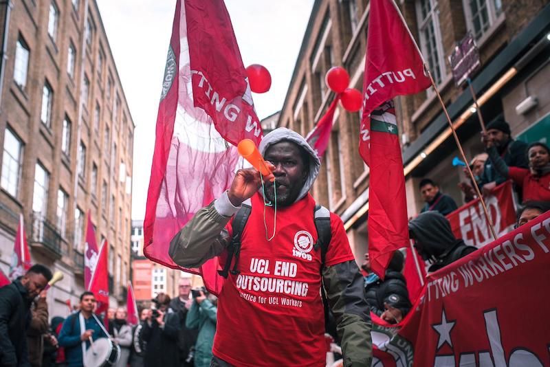Image may contain: Banner, Protest, Parade, Text, Flag, Symbol, Crowd, Human, Person