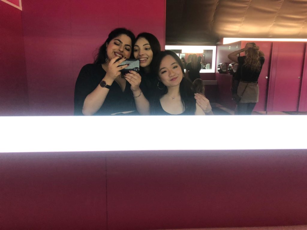 Three girls taking a picture in the mirror