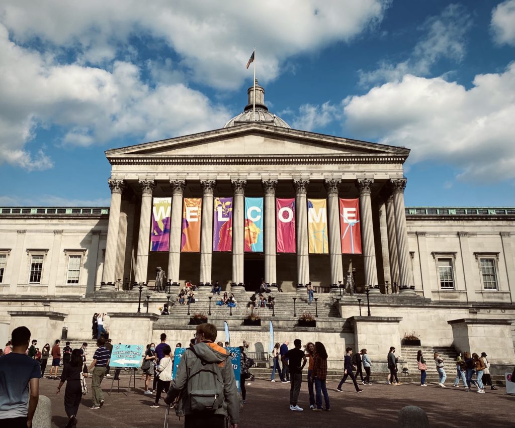 Horizontal photo showing frontal view of UCL's Portico with seven banners spelling out the word "welcome."
