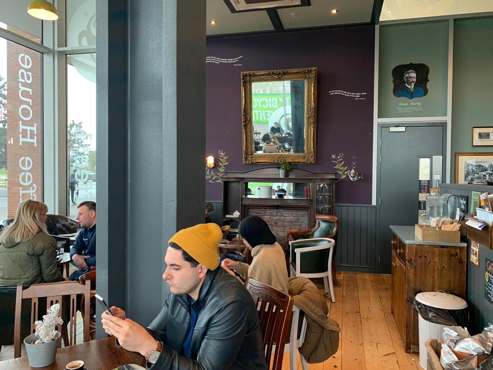 Image may contain: Furniture, Couch, Sitting, Plywood, Flooring, Food, Food Court, Cafeteria, Wood, Cafe, Person, Human, Restaurant