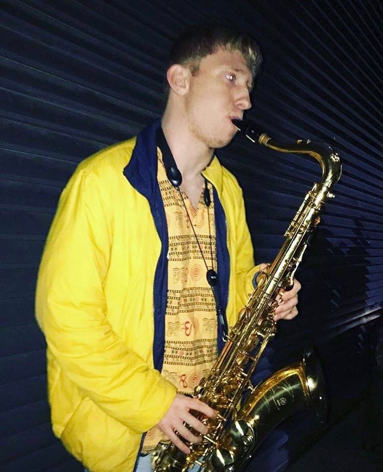 Image may contain: Brass Section, Horn, Guitar, Musical Instrument, Saxophone, Leisure Activities, Human, Person