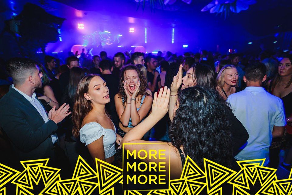 Image may contain: Night Club, Advertisement, Poster, Apparel, Coat, Clothing, Overcoat, Suit, Club, Party, Person, Human