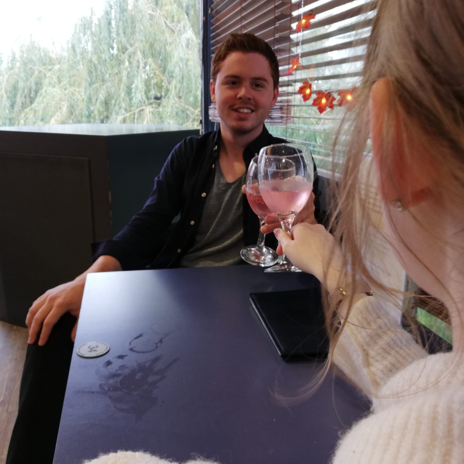 Image may contain: Dating, Dining Table, Furniture, Table, Wine Glass, Wine, Alcohol, Beverage, Drink, Goblet, Glass, Person, Human