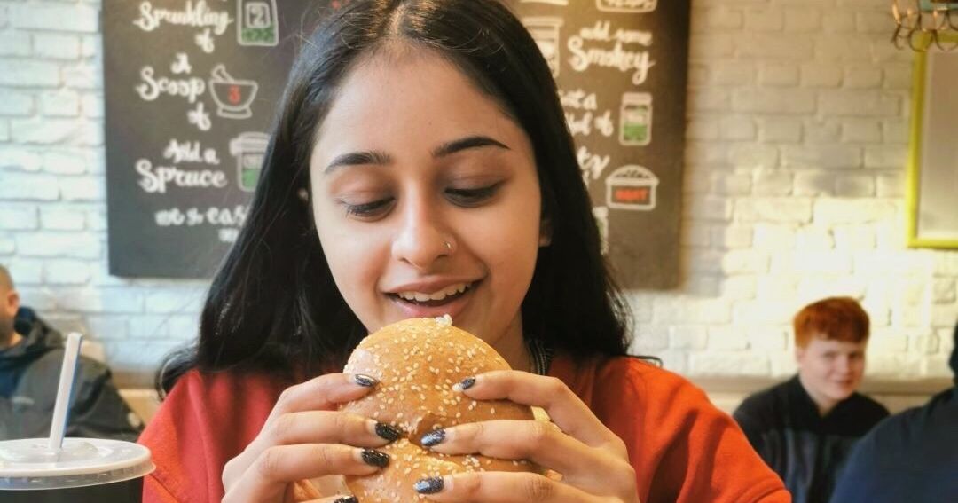Image may contain: Female, Burger, Eating, Food, Person, Human