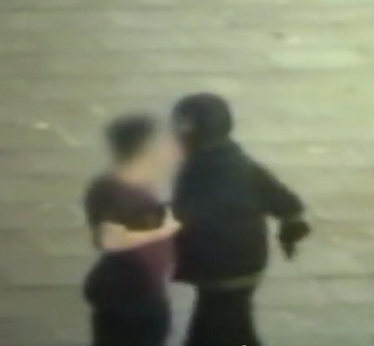 The student stands inches away from firearm