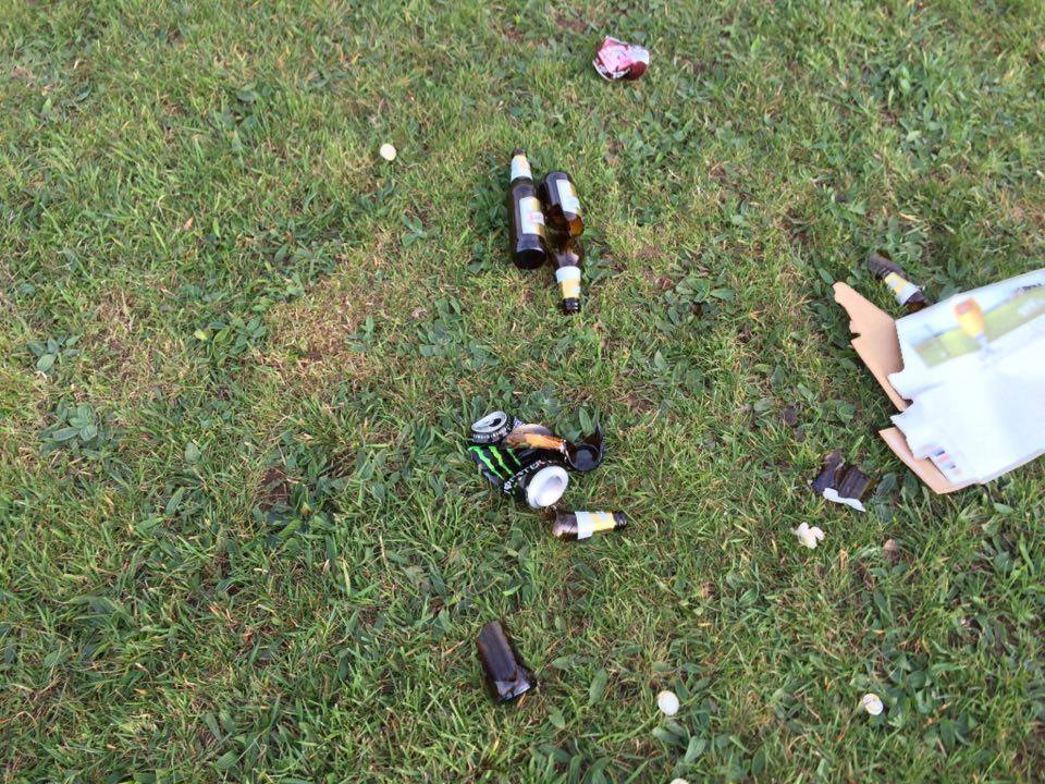 There are empty beer bottles strewn across the whole park