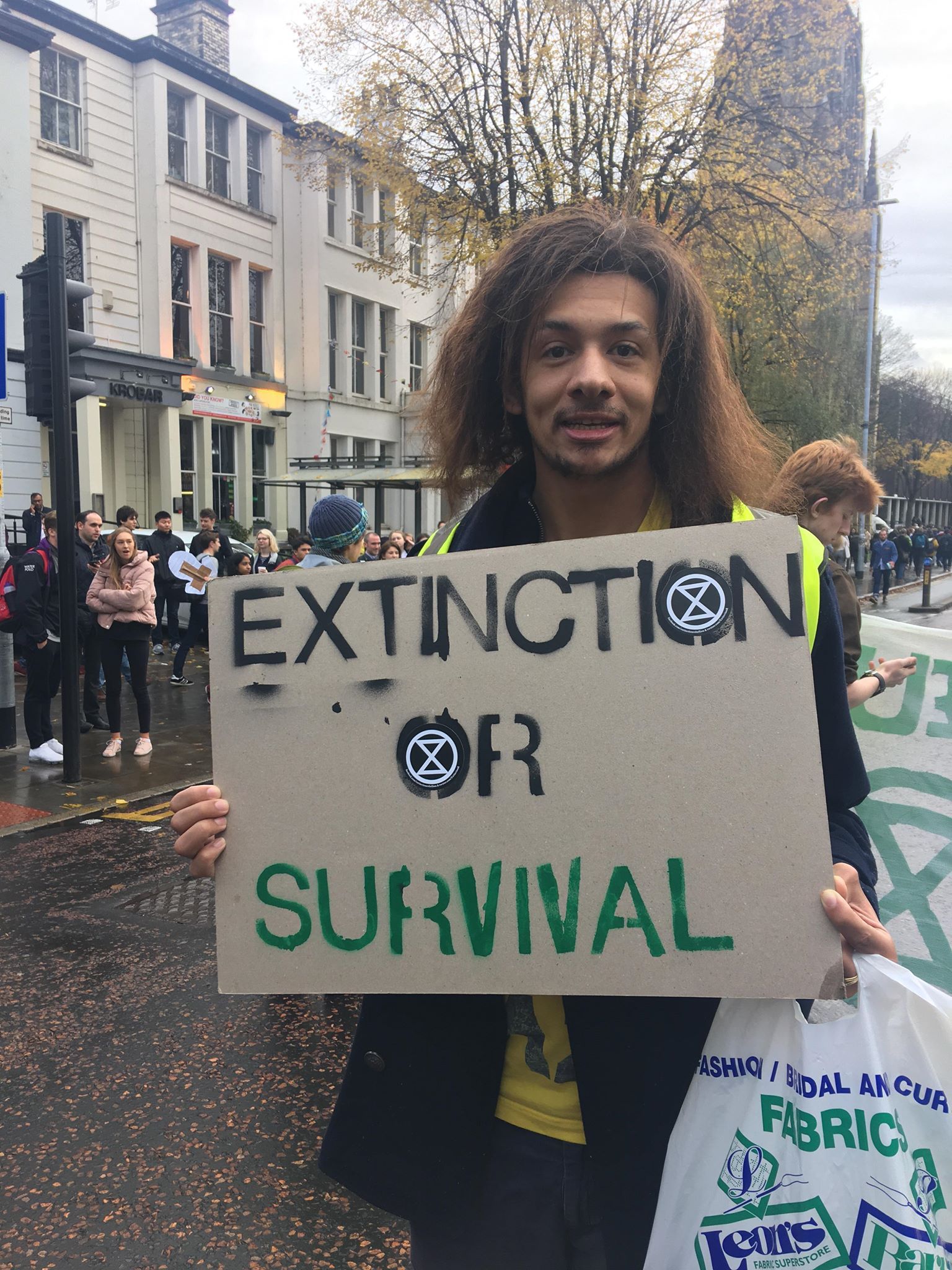 Image may contain: Banner, Sign, Pedestrian, Text, Symbol, Human, Person