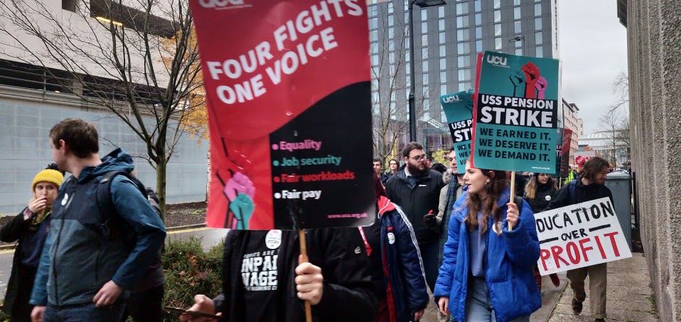 Image may contain: Crowd, Coat, Apparel, Jacket, Clothing, Person, Human, Banner, Text