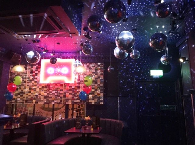 Image may contain: Stage, Glass, Pub, Bar Counter, Lighting, Furniture, Couch