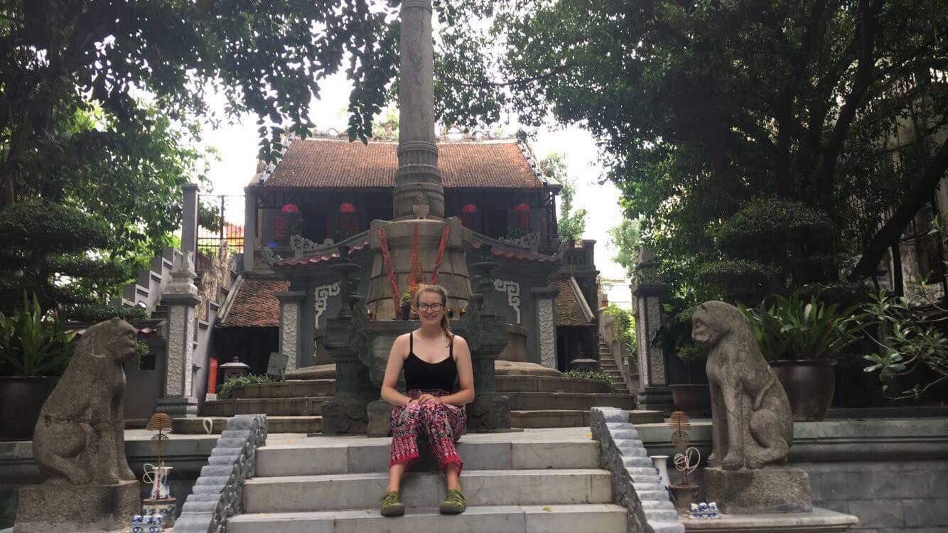 Image may contain: Buddha, Sculpture, Art, Worship, Temple, Building, Architecture, Person, People, Human, Vase, Pottery, Potted Plant, Plant, Jar, Flora