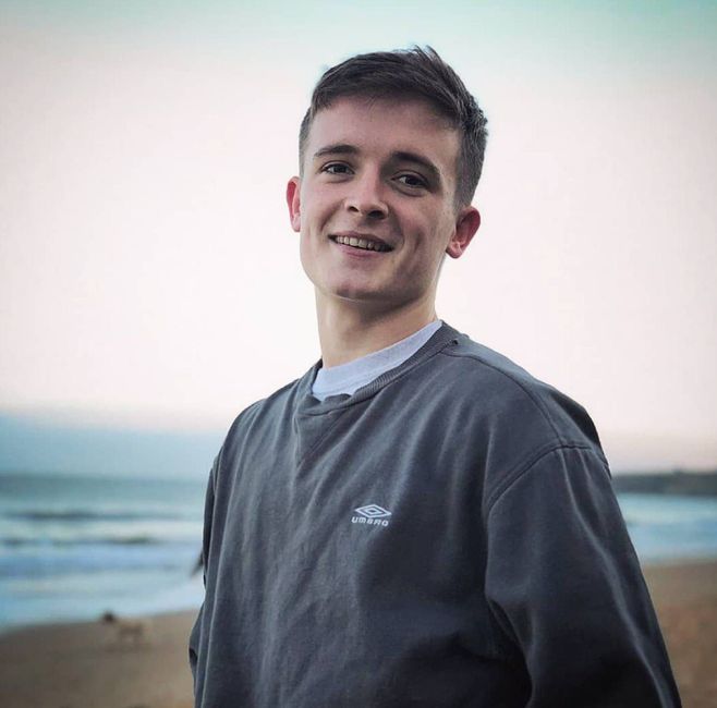 Image may contain: Boy, Beach, Coast, Shoreline, Sea, Nature, Ocean, Outdoors, Water, Face, Man, Sleeve, Apparel, Clothing, Human, Person