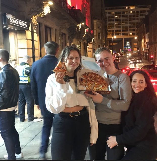 Image may contain: Female, Pizza, Jacket, Coat, Jeans, Denim, Face, Dish, City, Urban, Building, Town, Road, Street, Food, Meal, Pants, Clothing, Footwear, Apparel, Shoe, Person, Human