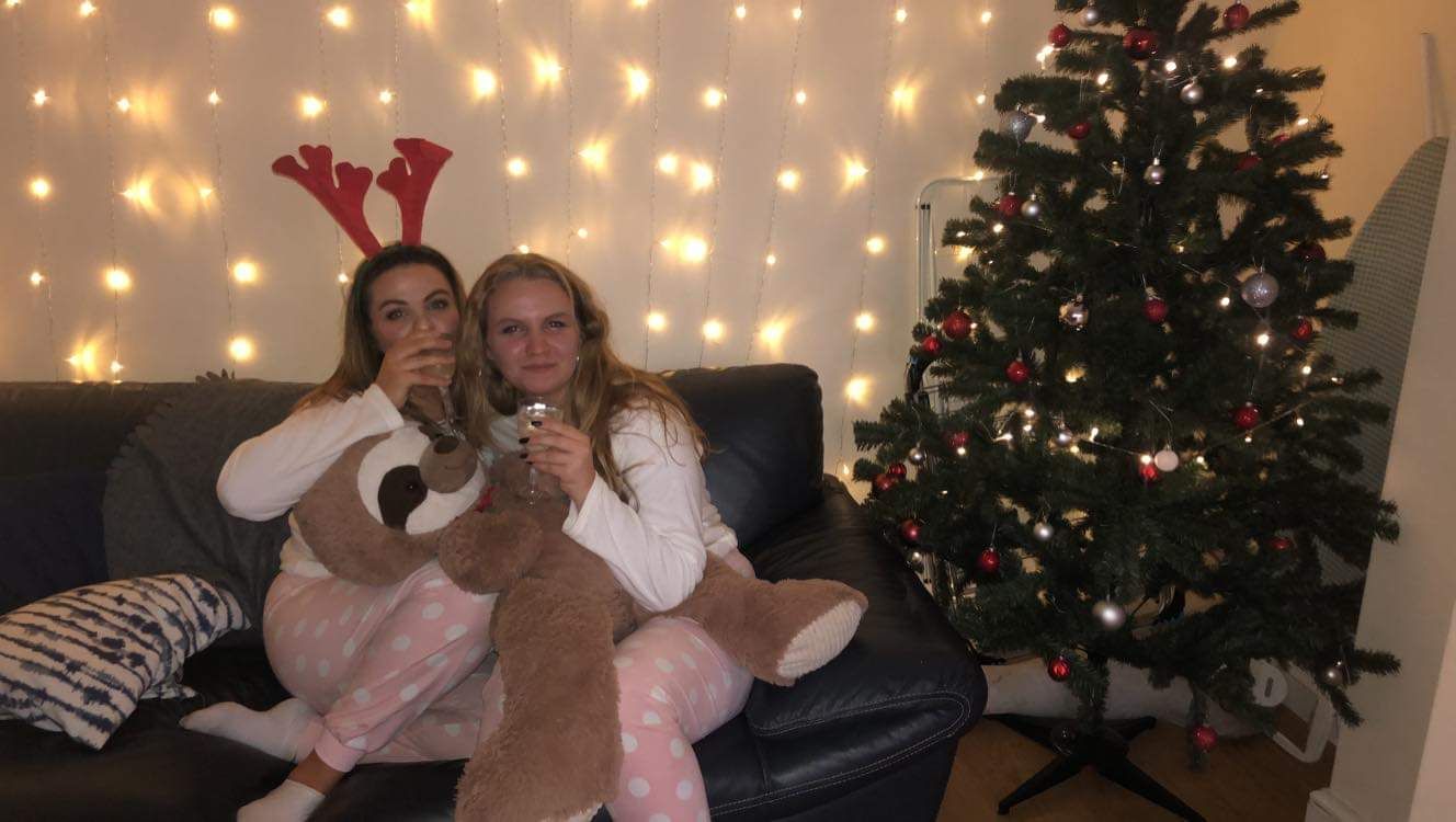 Image may contain: Interior Design, Indoors, Costume, Cushion, Apparel, Clothing, Human, Person, Couch, Furniture, Plant, Tree, Christmas Tree, Ornament