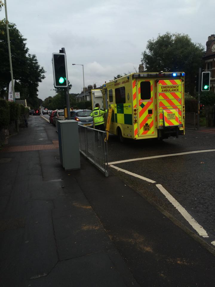 The ambulance was parked behind the two cars in front. 