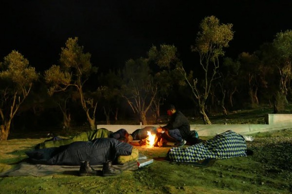 Sleeping around a fire under donated blankets to keep warm.