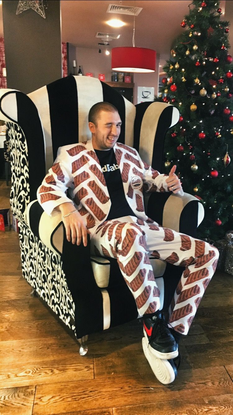 Image may contain: Plant, Tree, Ornament, Christmas Tree, Couch, Armchair, Human, Person, Shoe, Apparel, Footwear, Clothing, Chair, Furniture