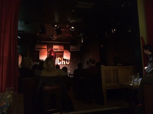 A girl, on a stage, making funnies