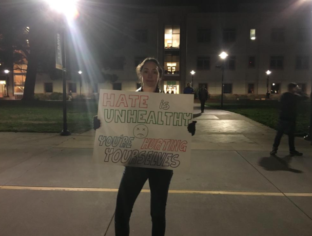 milo yiannopoulos protester holds a sign saying hate is unhealthy 