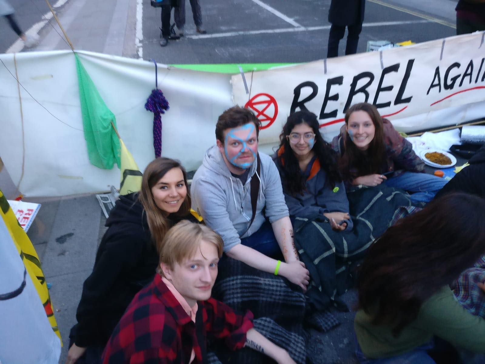Image may contain: Plant, Female, People, Face, Crowd, Pants, Banner, Text, Apparel, Clothing, Person, Human