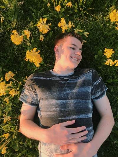 Image may contain: Petal, Photo, Photography, Portrait, Pants, Shirt, Flower, Blossom, Sleeve, Leaf, Boy, T-Shirt, Plant, Smile, Human, Person, Face, Clothing, Apparel