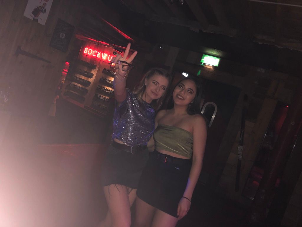 Image may contain: Woman, Bar Counter, Pub, Face, Night Life, Night Club, Skirt, Club, Female, Apparel, Clothing, Person, Human