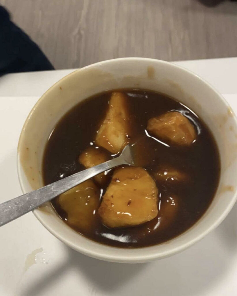 roast potatoes in a bowl of gravy