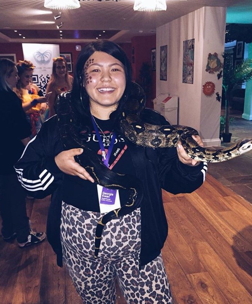 Image may contain: Purple, Face, Reptile, Animal, Rock Python, Snake, Female, Clothing, Apparel, Person, Human