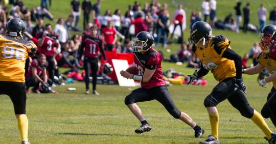 Image may contain: Footwear, Shoe, Football Helmet, Team Sport, Football, Team, American Football, Sport, Sports, People, Human, Person, Apparel, Clothing, Helmet
