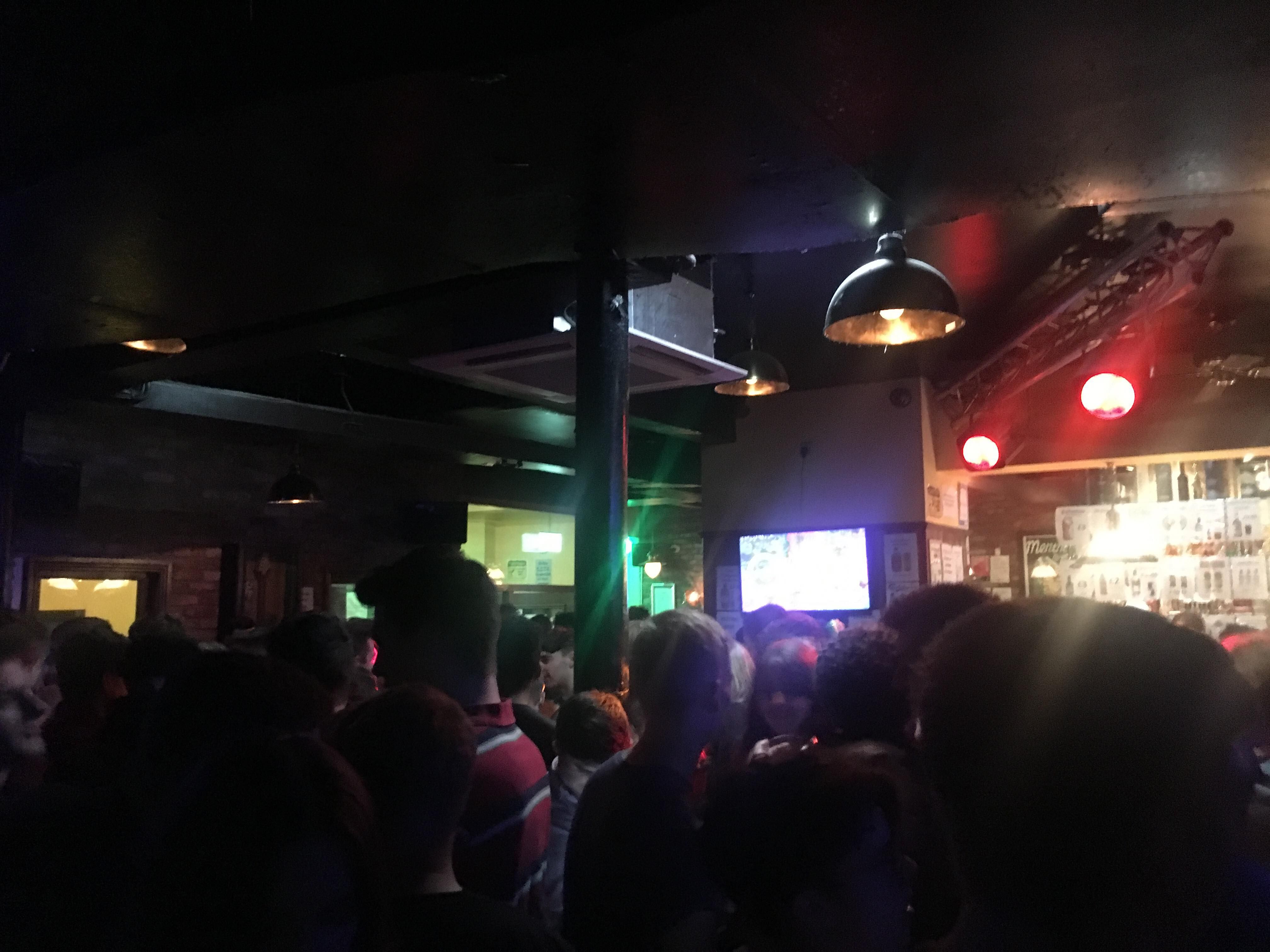Image may contain: Crowd, Pub, Bar Counter, Lighting, Person, People, Human, Television, TV, Screen, Monitor, Electronics