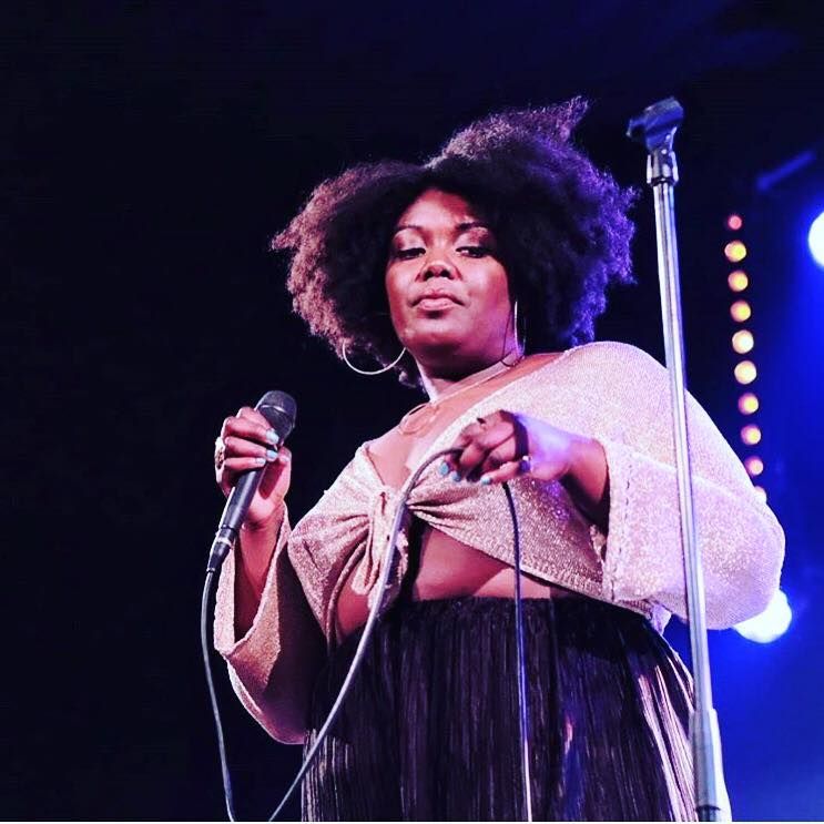 Image may contain: Performer, Hair, Afro Hairstyle, Person, People, Human