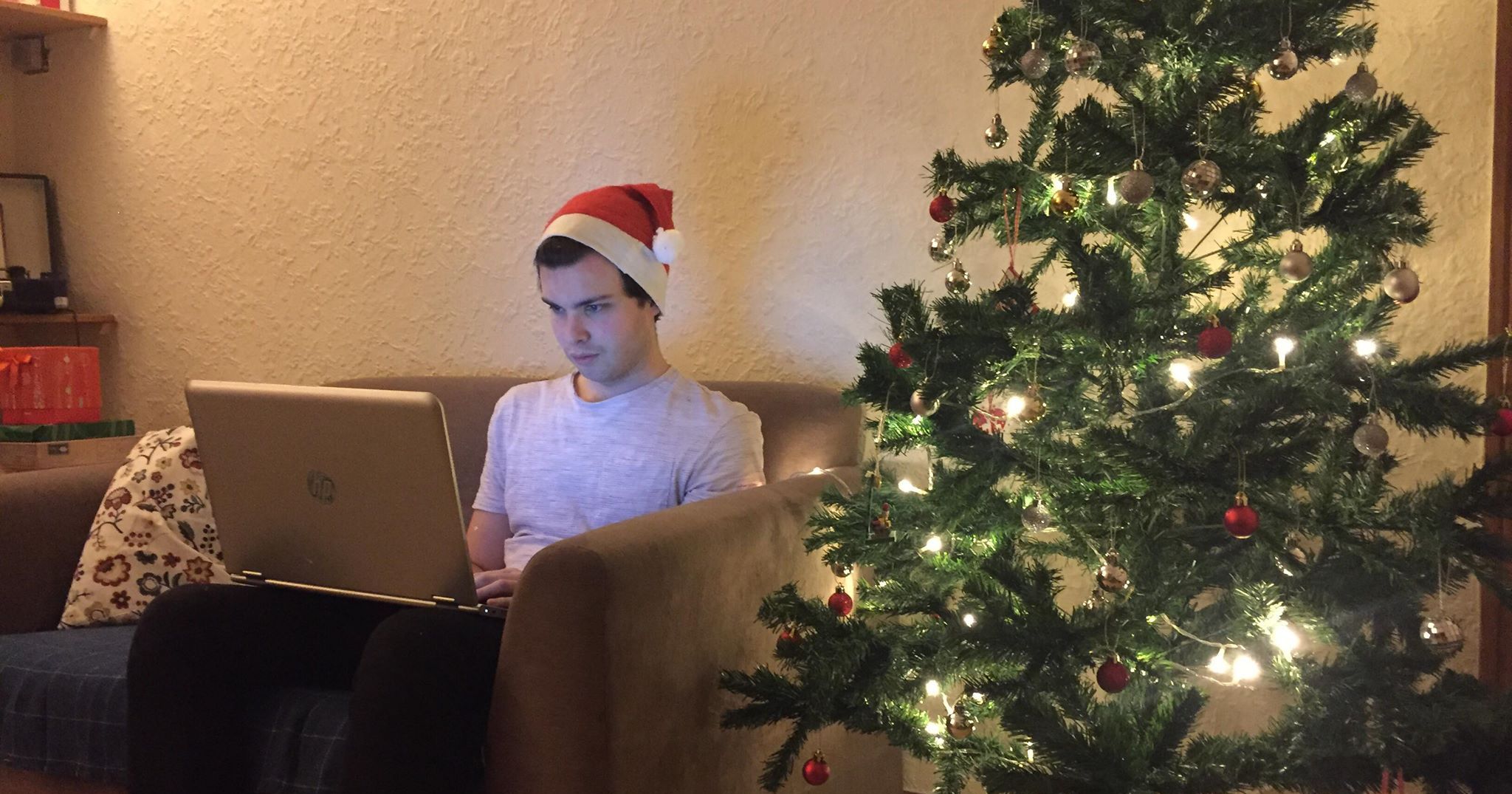 Image may contain: Sitting, Abies, Fir, Hat, Couch, Apparel, Clothing, Furniture, Electronics, Laptop, Computer, Pc, Human, Person, Christmas Tree, Plant, Tree, Ornament