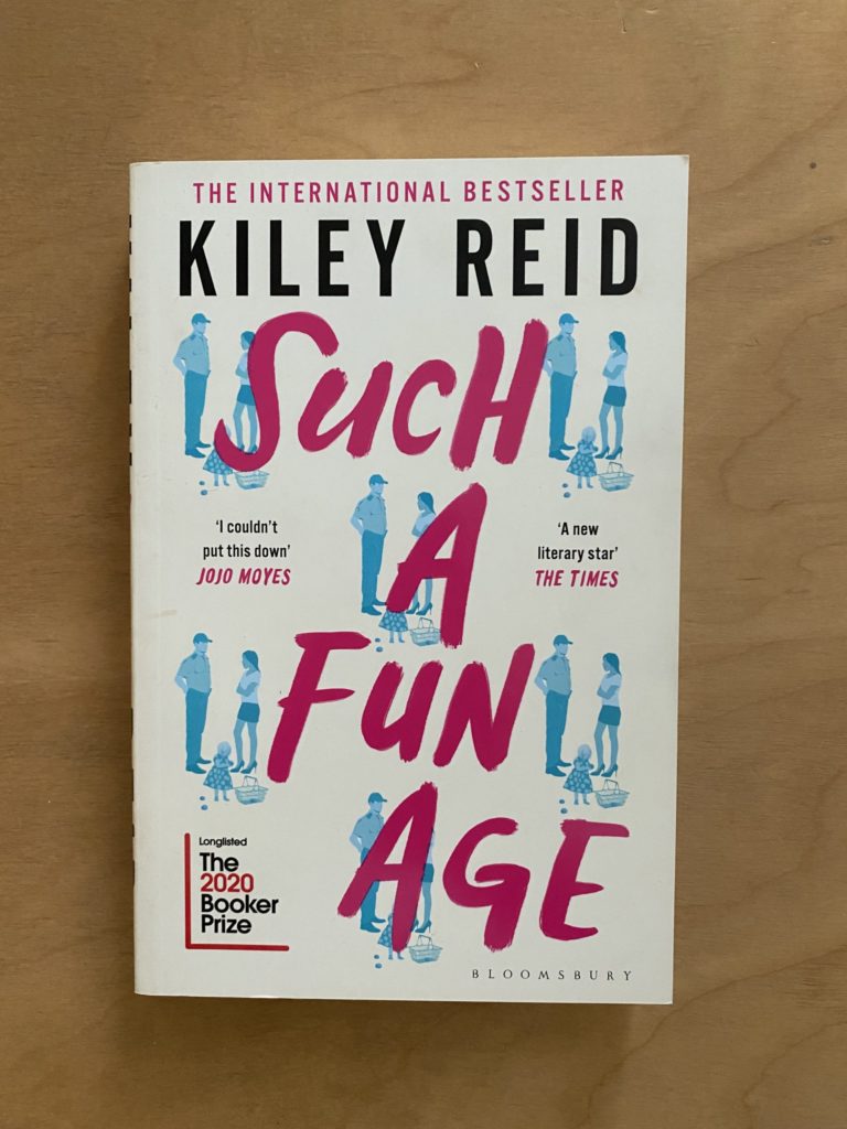 A white book with Images of a young woman with a child talking to shop security in blue and the title in pink on the cover.