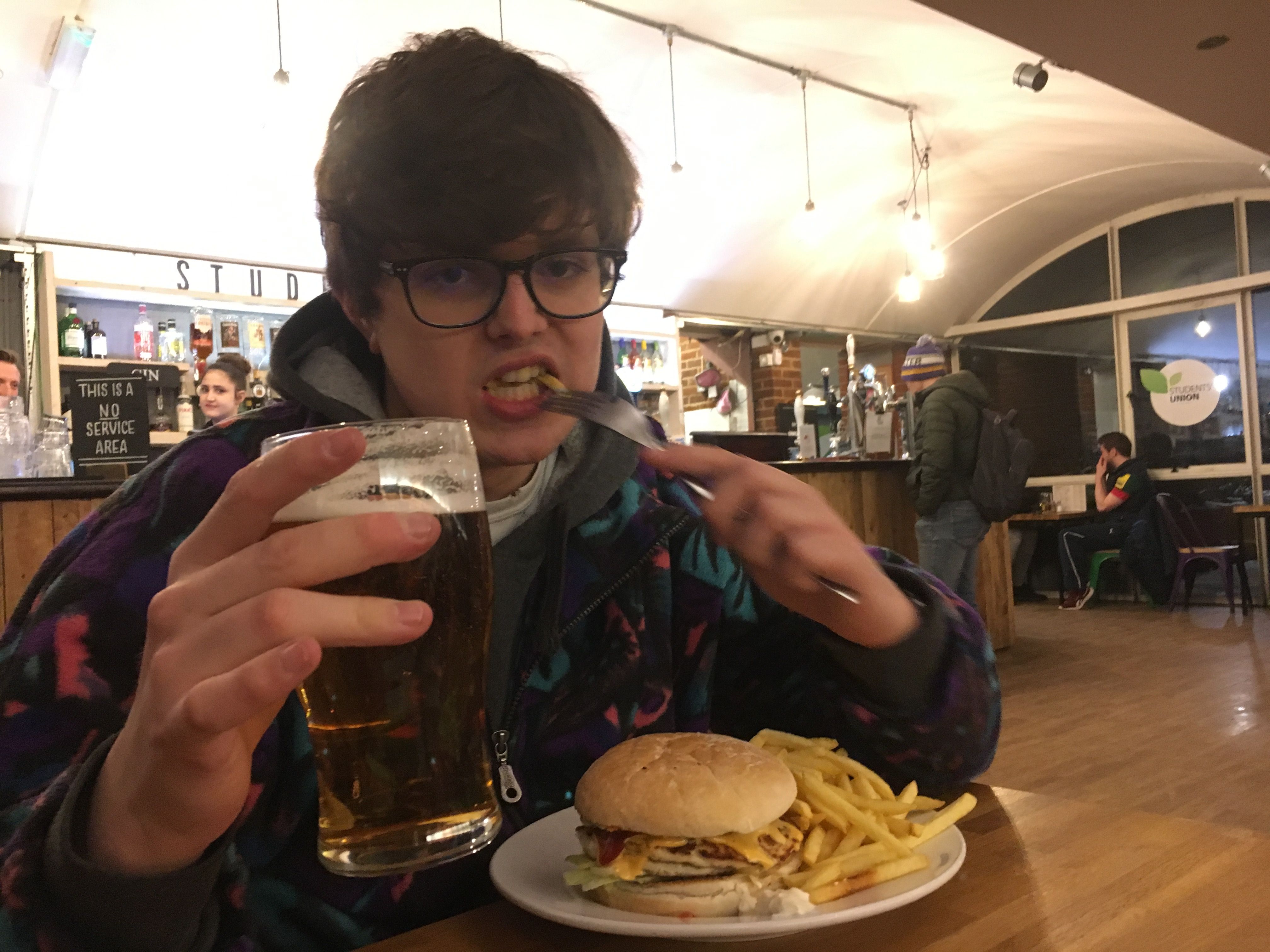 Image may contain: Glass, Restaurant, Cafe, Food, Burger, Person, People, Human